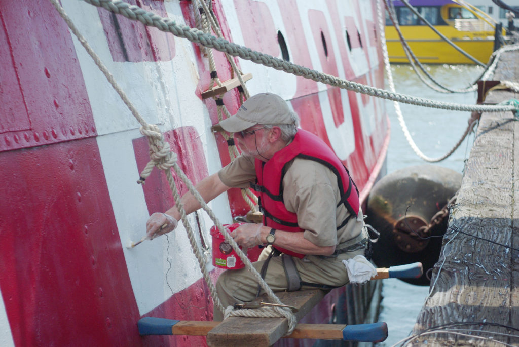 A volunteer painting lightship Ambrose exterior