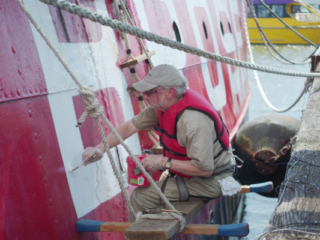 A volunteer painting lightship Ambrose exterior