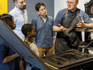 Bowne &amp; Co. 's Art Director and Operation Manager Robert Wilson teaching visitors about the art of letterpress printing