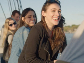 Guests aboard the historic schooner Pioneer helping haul up the main sail