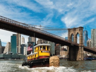 The newly restored tugboat W.O. Decker cruising past the seaport district and the Brooklyn Bridge