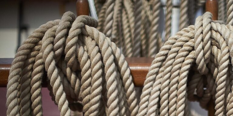 Ropes tied on the rail of a ship.
